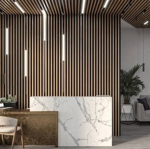 Linear slatted ceiling with recessed lights above a dining and lounge space