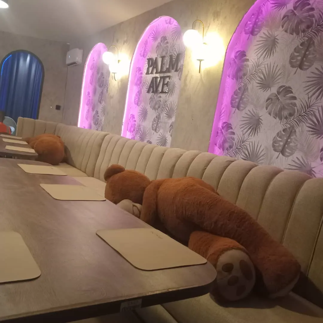 Arched decorative wall panels with integrated lighting above built-in upholstered banquette seating