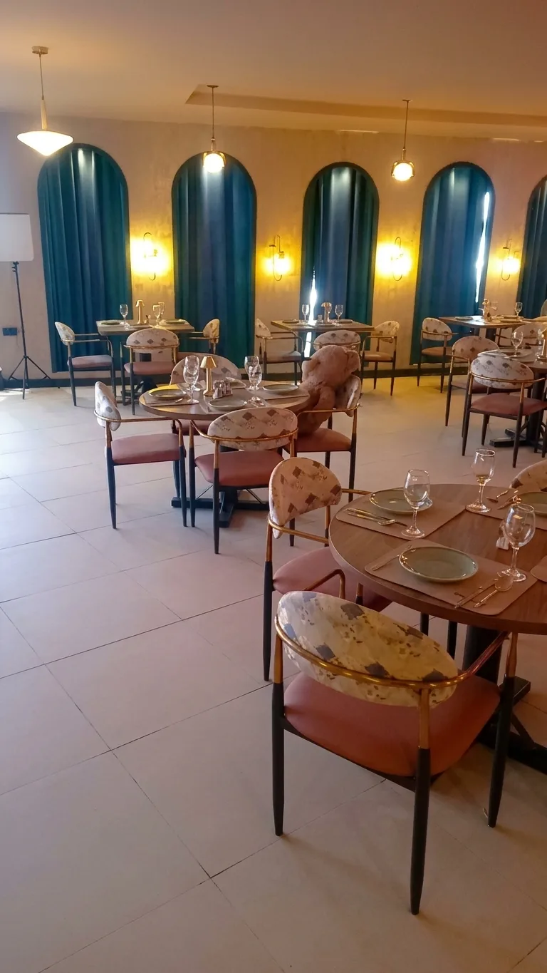 AI-generated image: dining hall with arched windows in teal curtains, pendant lights and upholstered chairs